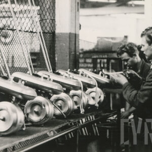 mężczyzna w średnim wieku ubrany w strój roboczy, przykręcający elementy silników