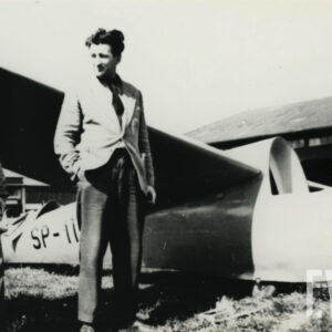 trzech mężczyzn przy samolocie leżącym na trawiastym lądowisku