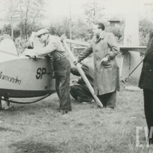 grupa mężczyzn przy zdekompletowanym samolocie leżącym na trawiastym podłożu