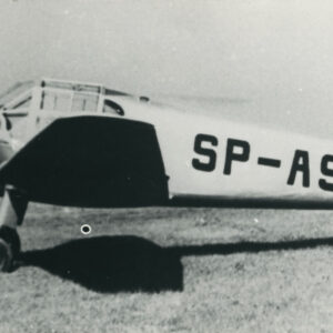 samolot stojący na porośniętym trawą gruncie