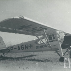 samolot stojący na porośniętym trawą gruncie