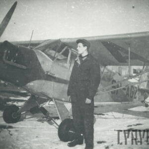 mężczyzna stojący przy samolocie na lądowisku pokrytym śniegiem