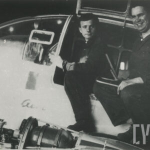 dwóch mężczyzn siedzących na skrzydle samolotu