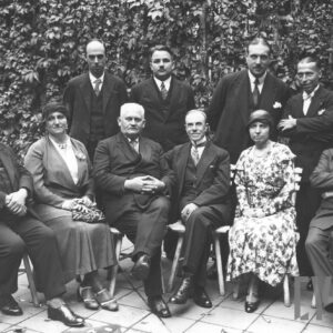 grupa osób, siedzą czterech mężczyzn i dwie kobiety, stoi czterech mężczyzn, na tle zieleni 