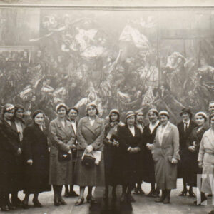 duża grupa kobiet stoi na tle wielkiego obrazu ze sceną orszaku