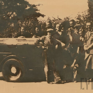 grupa osób stoi przy transportowanym pojeździe mechanicznym