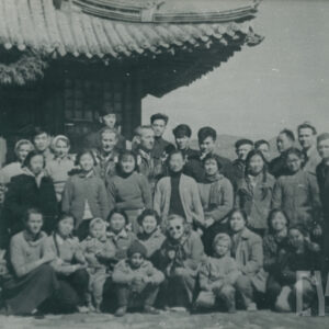 grupa osób pozująca do fotografii na tle budynku utrzymanego w stylu architektury chińskiej