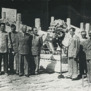 grupa mężczyzn pozująca do fotografii przed budynkiem wybudowanym w stylu tradycyjnej architektury chińskiej