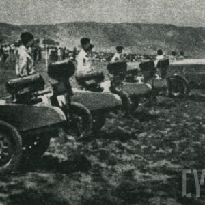 pojazdy mechaniczne na kołach, ustawione w rzędzie na trawiastym lądowisku, obok maszyn stoją pracownicy 