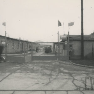 brama wjazdowa na teren, na którym stoją w szeregu budynki przemysłowe