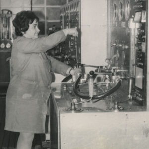 kobieta w stroju roboczym obsługująca urządzenie do testowania sprawności zaworów