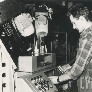 mężczyzna w stroju roboczym stojący przy maszynie