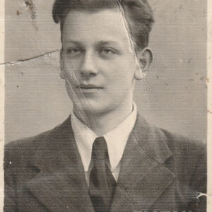 młody mężczyzna, ubrany elegancko w koszulę, krawat i marynarkę