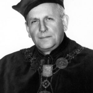 starszy mężczyzna w todze rektorskiej z łańcuchem z godłem na szyi