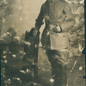 młody mężczyzna w mundurze i czapce pozujący w atelier do fotografii