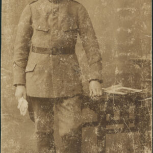 młody mężczyzna w mundurze i czapce pozujący w atelier do fotografii