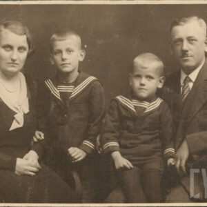 mężczyzna i kobieta w średnim wieku z dwójką młodych chłopców, wszyscy elegancko ubrani pozują do fotografii