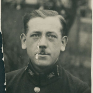 mężczyzna w średnim wieku z wąsikiem, ubrany w mundur pracownika pocztowego