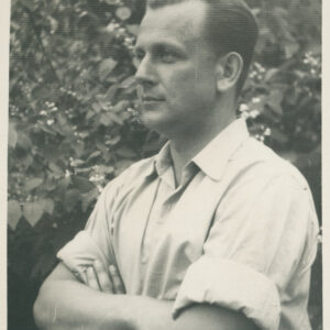 młody mężczyzna w koszuli z podwiniętymi rękawami pozujący do fotografii na tle drzew