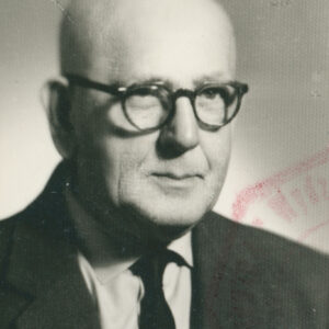 starszy mężczyzna w okularach, ubrany w garnitur, koszulę i krawat