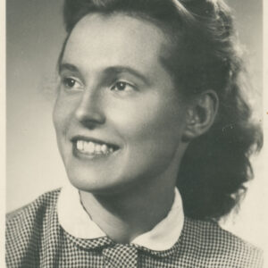 młoda, uśmiechnięta, elegancko ubrana kobieta pozująca do fotografii