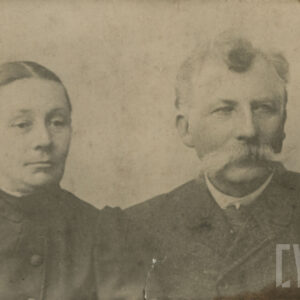 dwoje starszych elegancko ubranych ludzi: kobieta i mężczyzna z bujnym wąsem, pozujących do fotografii