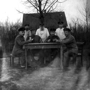 grupa mężczyzn w mundurach wojskowych, siedzących przy stole i grających w karty