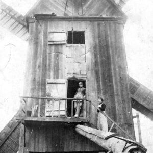 mężczyzna i kobieta stojący na schodach dużego, drewnianego wiatraka 