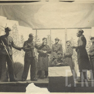 grupa młodych ludzi przebranych w różne stroje, pozujących do fotografii na tle prowizorycznej scenografii