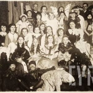 grupa młodych ludzi przebranych w różne stroje, część z nich trzyma w dłoniach rekwizyty, pozuje do fotografii na tle prowizorycznej scenografii