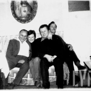 czterech uśmiechniętych mężczyzn, siedzących na wersalce i pozujących do fotografii