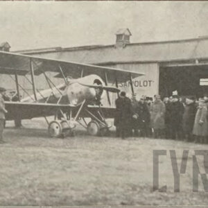 tłum ludzi stojących przy samolocie na tle drewnianych budynków