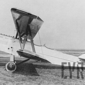 samolot dwupłatowy stojący na pustej trawiastej przestrzeni