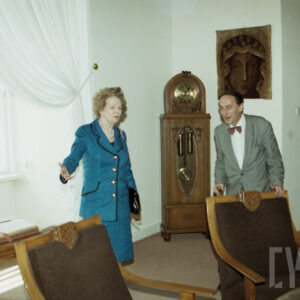 starsza kobieta i starszy mężczyzna w eleganckich ubraniach, stojący w gabinecie ze zdobionymi, eleganckimi meblami