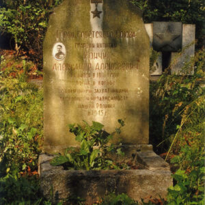 płyta nagrobna o nieregularnym kształcie z wyrytymi cyrylicą napisami w języku rosyjskim oraz umieszczoną fotografią