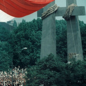 opadająca biało-czerwona flaga, odsłaniająca stalowe krzyże