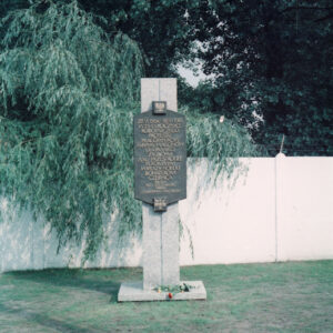 tablica ze złotymi literami ułożonymi w wyrazy, umieszczona na postumencie