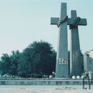 grupa osób stojących pod stalowym pomnikiem w formie dwóch krzyży i monumentu z głową orła