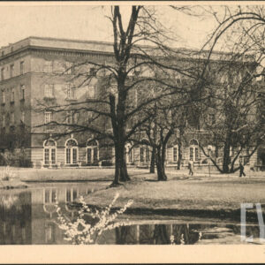 park ze stawem i drzewami, w głębi duży, czterokondygnacyjny budynek z rzędami okien