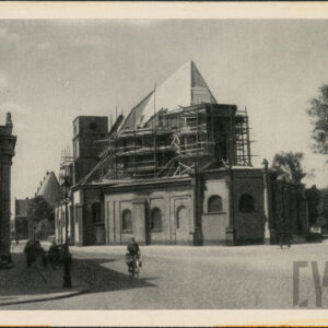 prezbiterium katedry otoczone rusztowaniami w partii dachu, na pierwszym planie brukowana ulica, rowerzysta i piesi