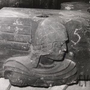 kamienny prostopadłościan o nierównych kształtach z widocznymi fragmentami płaskorzeźby