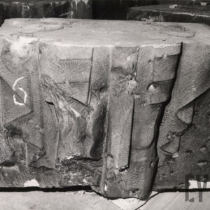 kamienny prostopadłościan o nierównych kształtach z widocznymi fragmentami płaskorzeźby