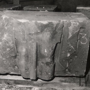 kamienny prostopadłościan o nierównych kształtach z widocznymi fragmentami płaskorzeźby