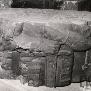 kamienny prostopadłościan o nierównych kształtach z widocznymi fragmentami płaskorzeźby