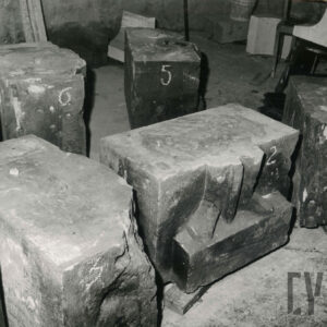 kamienny prostopadłościan o nierównych kształtach z widocznymi fragmentami płaskorzeźby