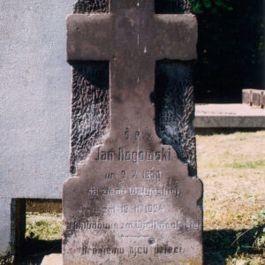 poszarzała, przybrudzona stela z płaskorzeźbą krzyża