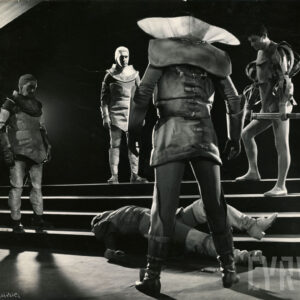 grupa mężczyzn stojąca nad jednym mężczyzną leżącym na schodach