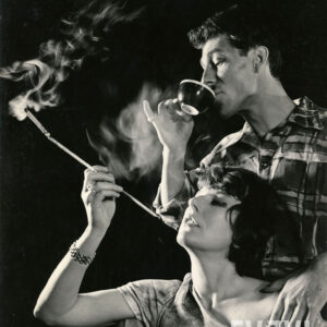 elegancka kobieta paląca fajkę obok mężczyzna pijący z filiżanki