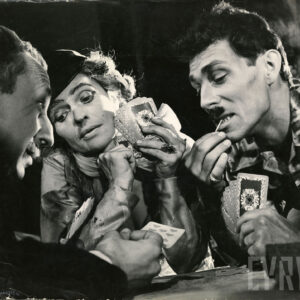 dwóch mężczyzn i jedna kobieta siedzący przy stole grający w karty