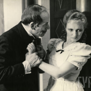 starszy mężczyzna trzymający za ręce młodą, odpychającą go kobietę